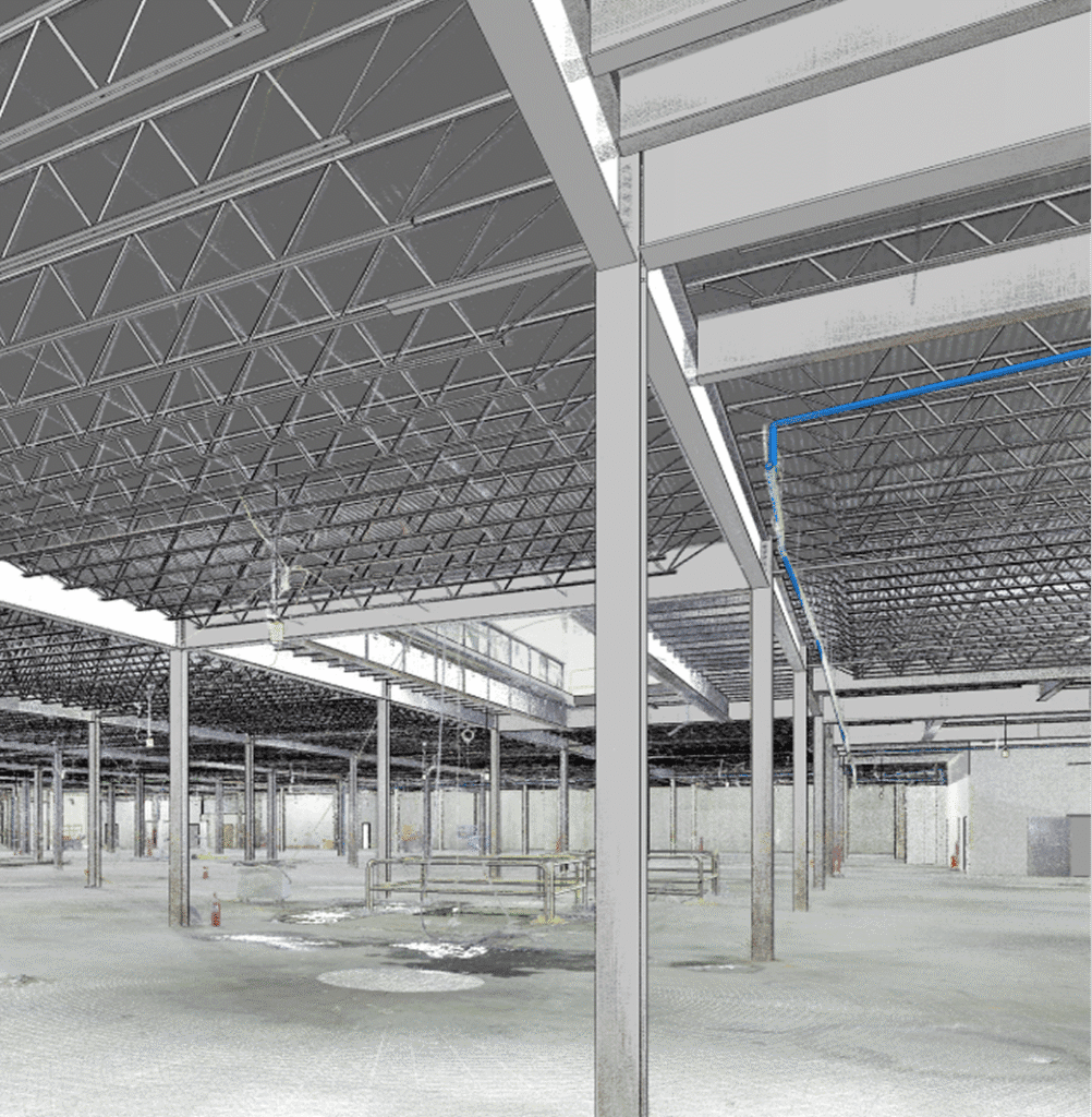 nterior view of a large industrial warehouse featuring exposed steel trusses and I-beams overhead, evenly spaced support columns rising from a concrete floor, with blue utility piping running along the ceiling.